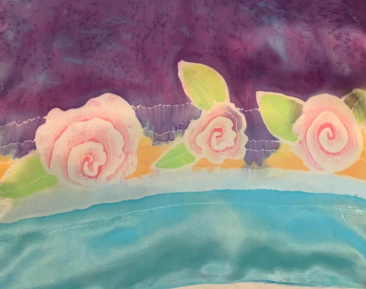 A painting of roses on the side of a cake.