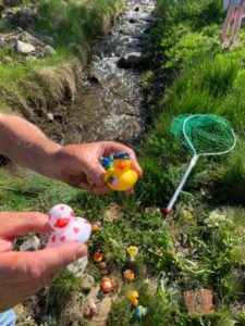 Two people holding plastic toys in a field.